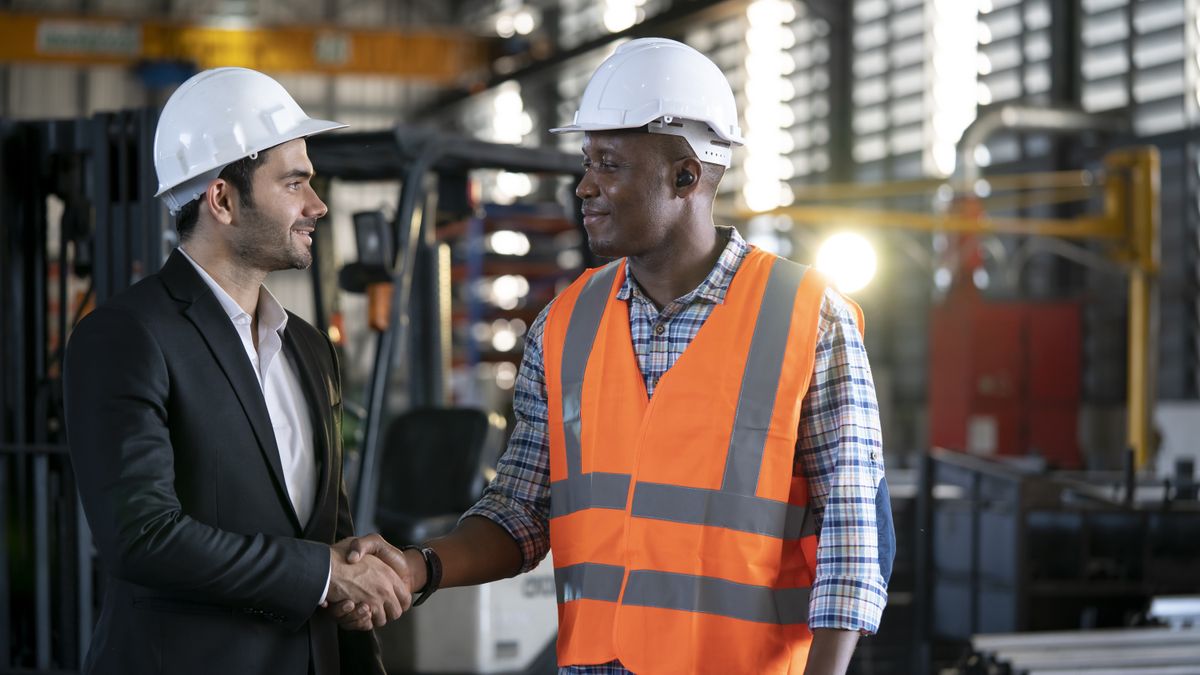 Two warehouse workers shaking hands.