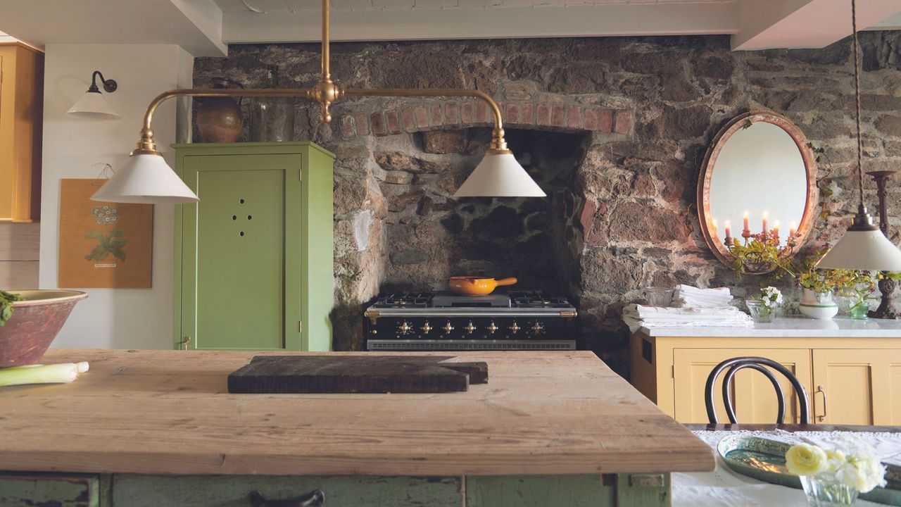 coastal kitchen with brick wall and green cabinet and wooden table