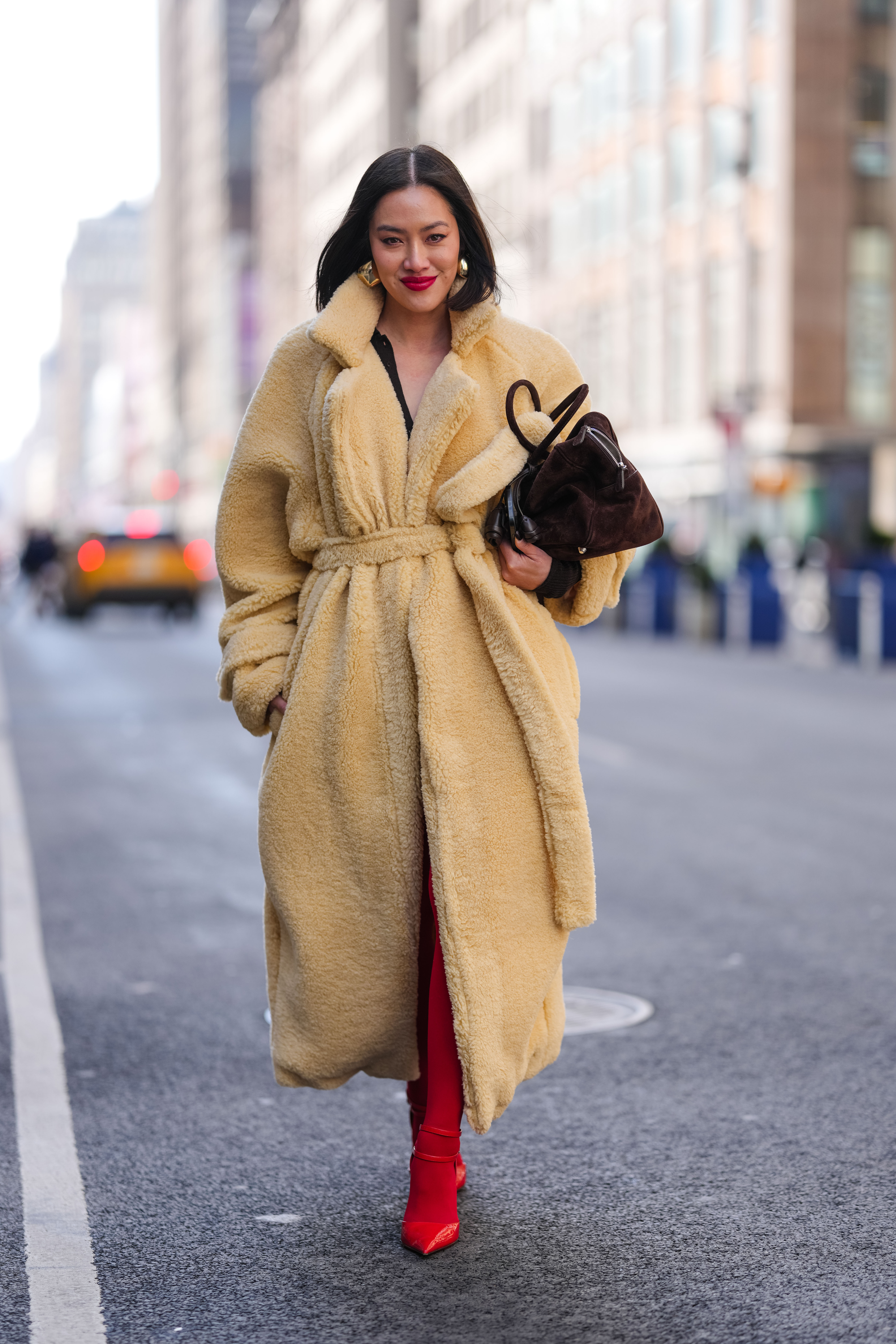 tiffany hsu wearing a maxi coat and red statement tights