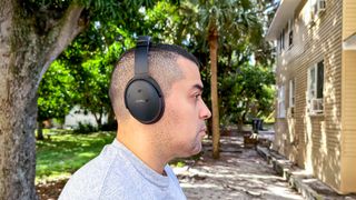 Reviewer testing ANC performance on QC Headphones outside