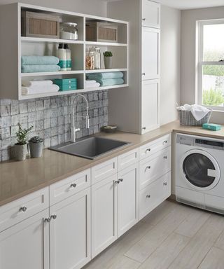 Liven laundry sink by blanco in a laundry room with white cabinetry and open shelving unit