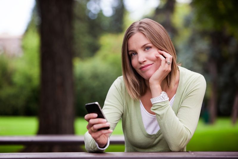 Woman texting on cellphone in the park