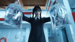 Wednesday Addams holding bags of goldfish in Netflix's Wednesday