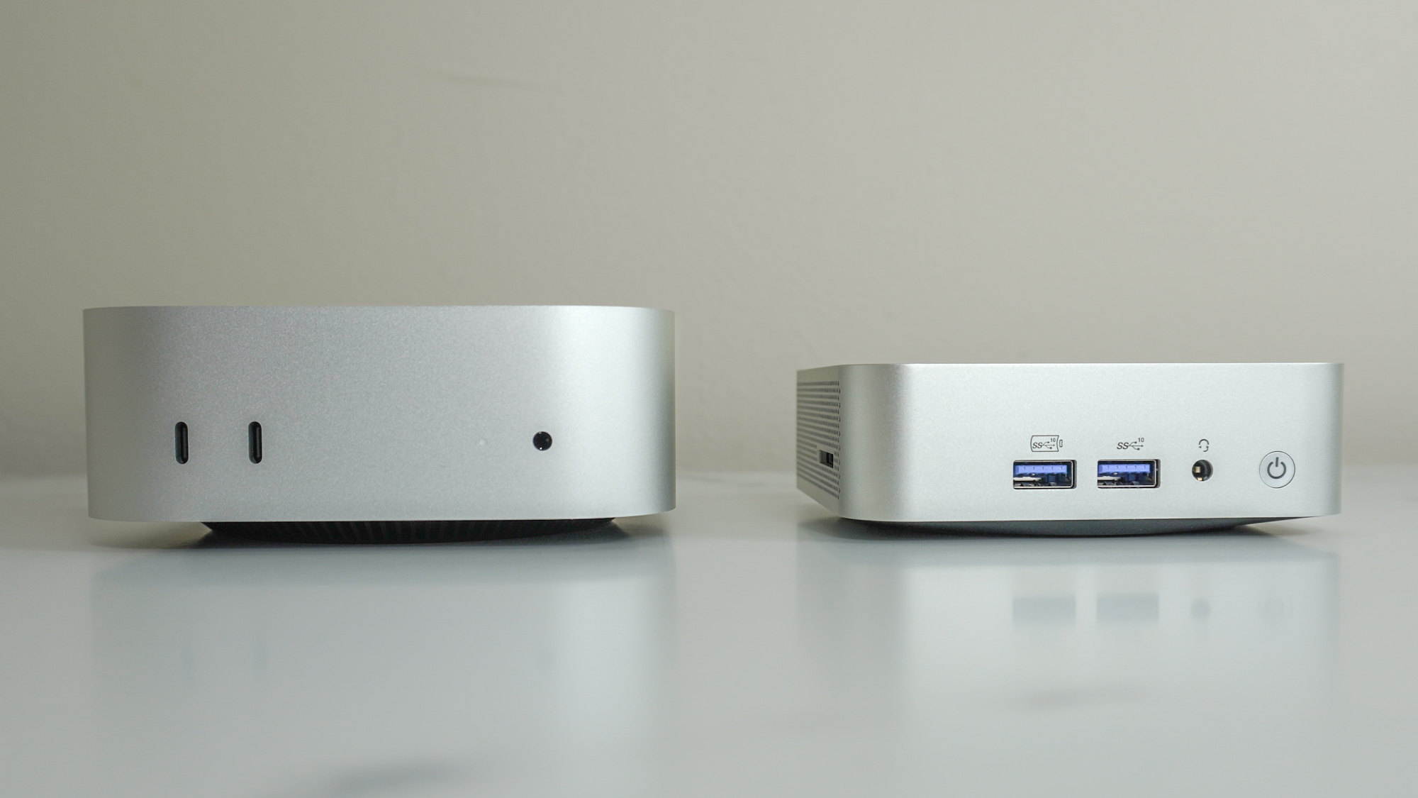 The Geekom A6 next to the Mac mini M4 showing the front ports of both devices