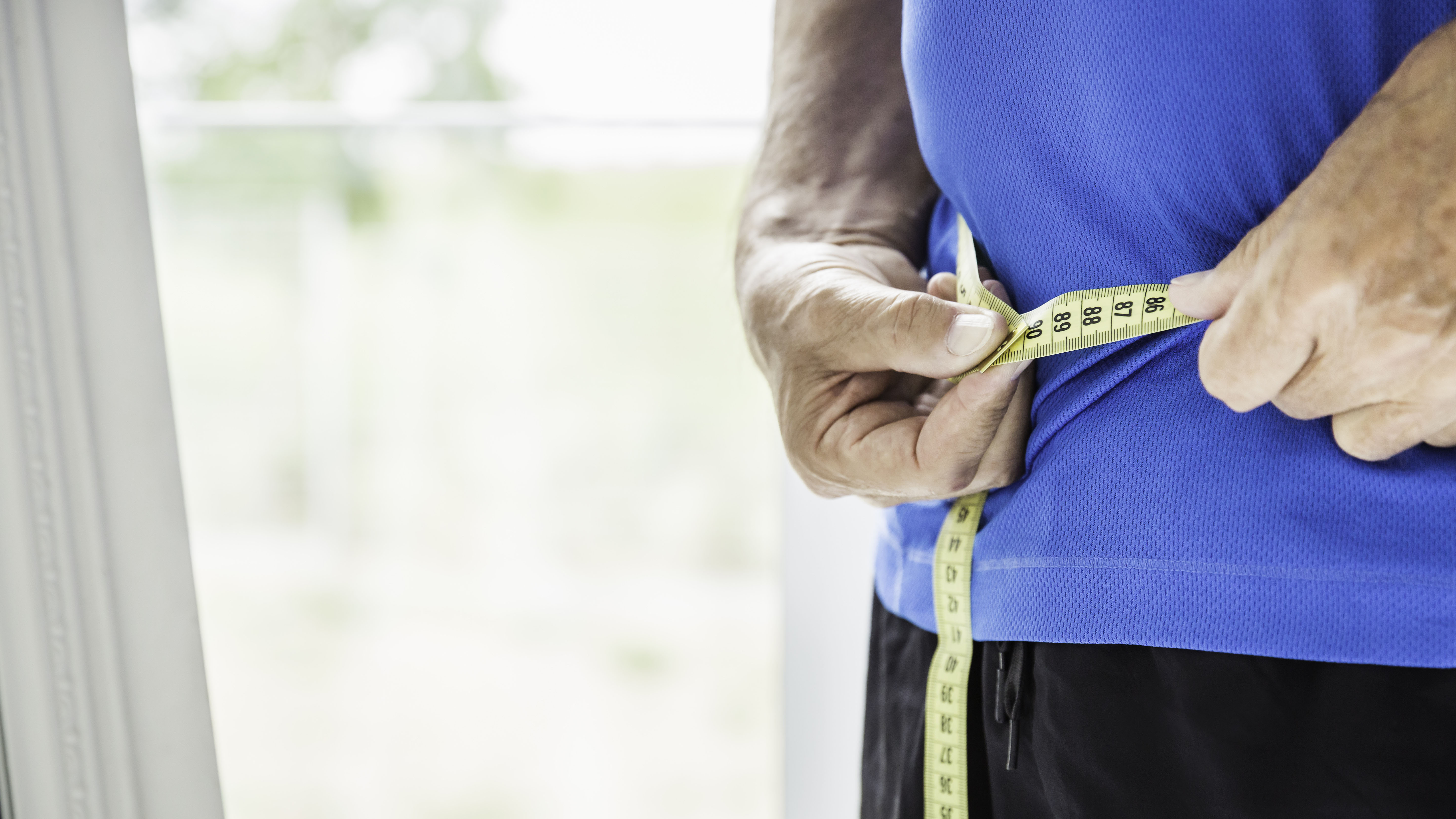 Cropped shot of senior man measuring waist