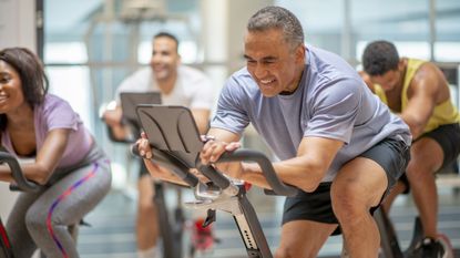 Man riding in group indoor cycling class