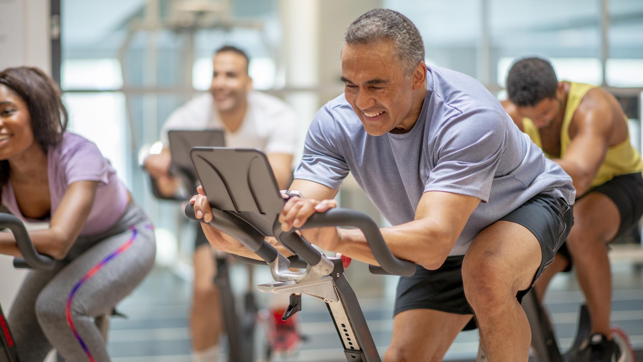 Man riding in group indoor cycling class