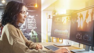 Une femme utilise un logiciel de montage vidéo sur son ordinateur de bureau