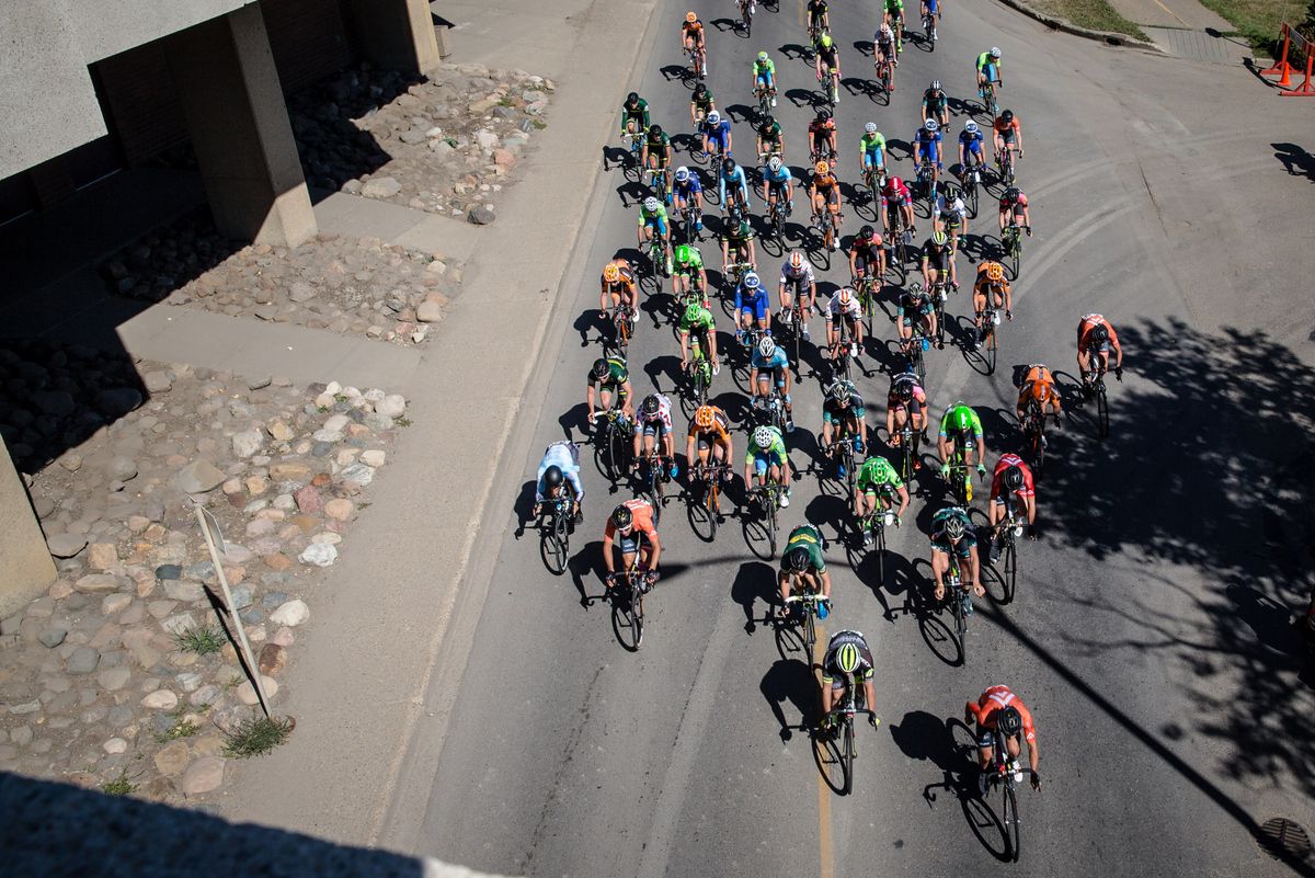 The peloton rolls under a bridge on the city course