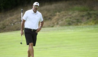 Mickelson walks with a putter in his hand