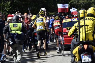 Chris Froome runs beside Richie Porte after his bike was broken during an incident with a TV motorbike in the last kilometer of Stage 12 of the 2016 Tour de France