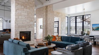 open plan living room with fire lit and dining room beyond with view back to kitchen in the distance