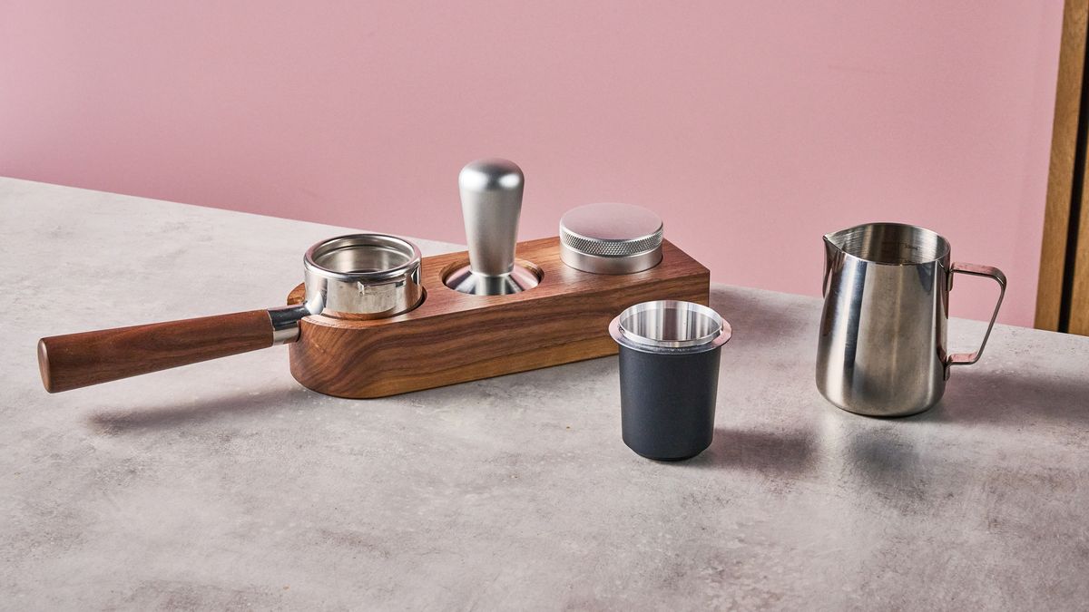 Some of the Meraki Espresso Machines accessories, including its portafilter, tamp, coffee distributor, dosing cup and milk jug.