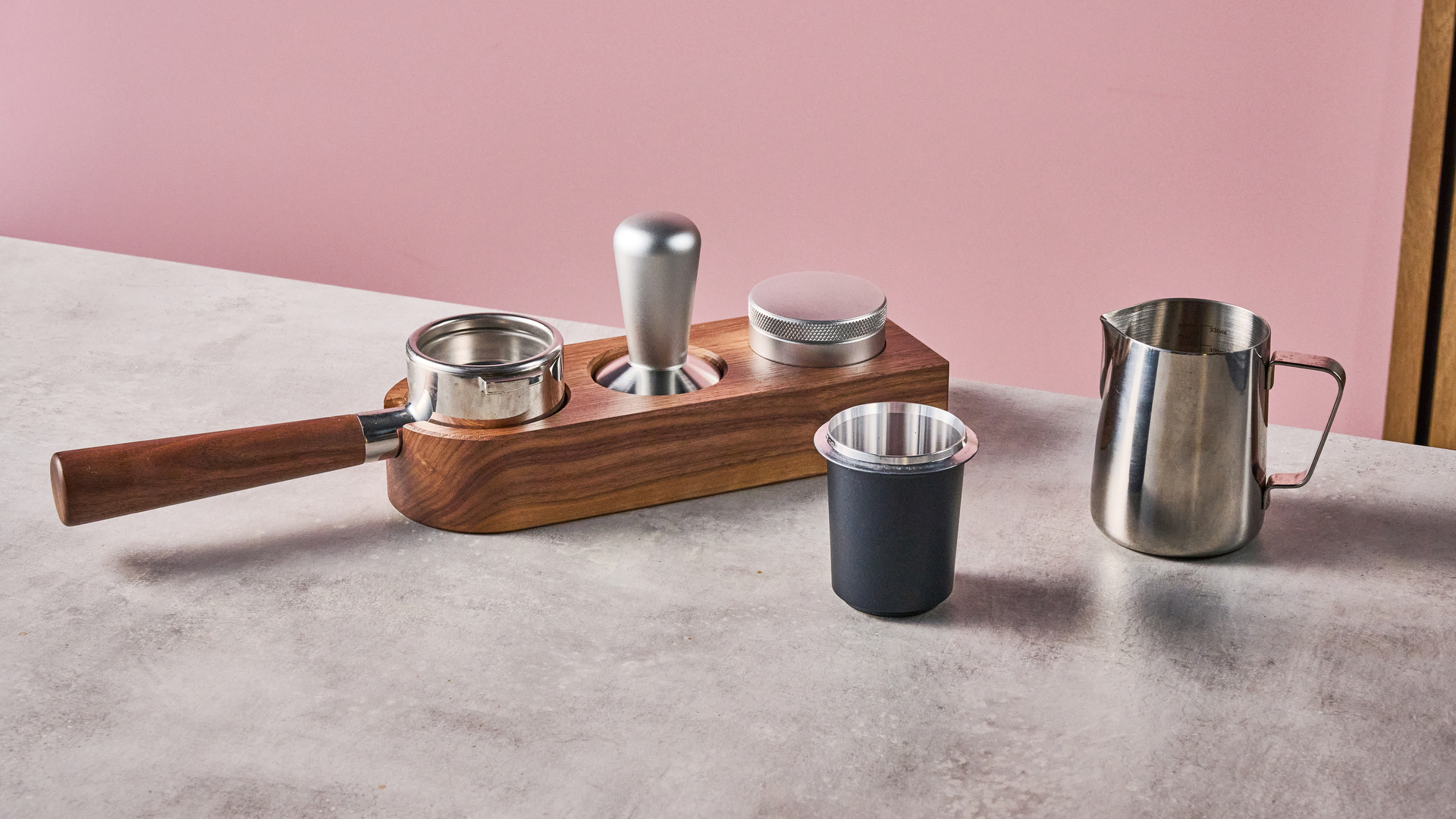 Some of the Meraki Espresso Machines accessories, including its portafilter, tamp, coffee distributor, dosing cup and milk jug.