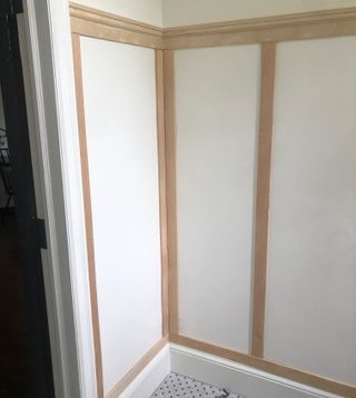 DIY board and batten wall paneling in an entry on white walls