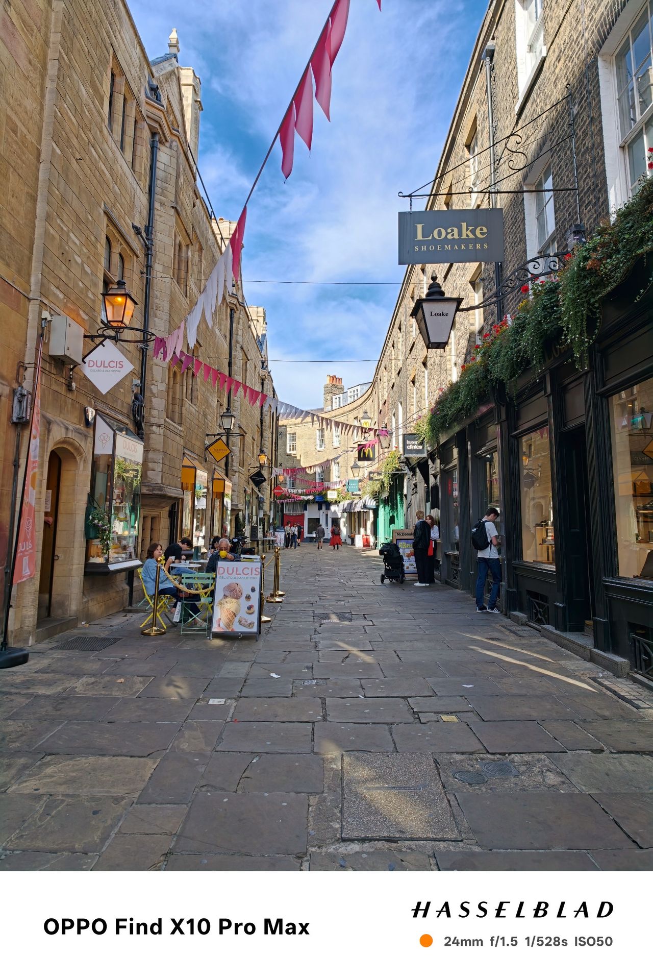 Narrow Cambridge shopping street decorated with pink bunting.