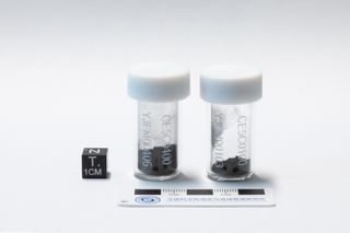 two glass vials containing grey dirt