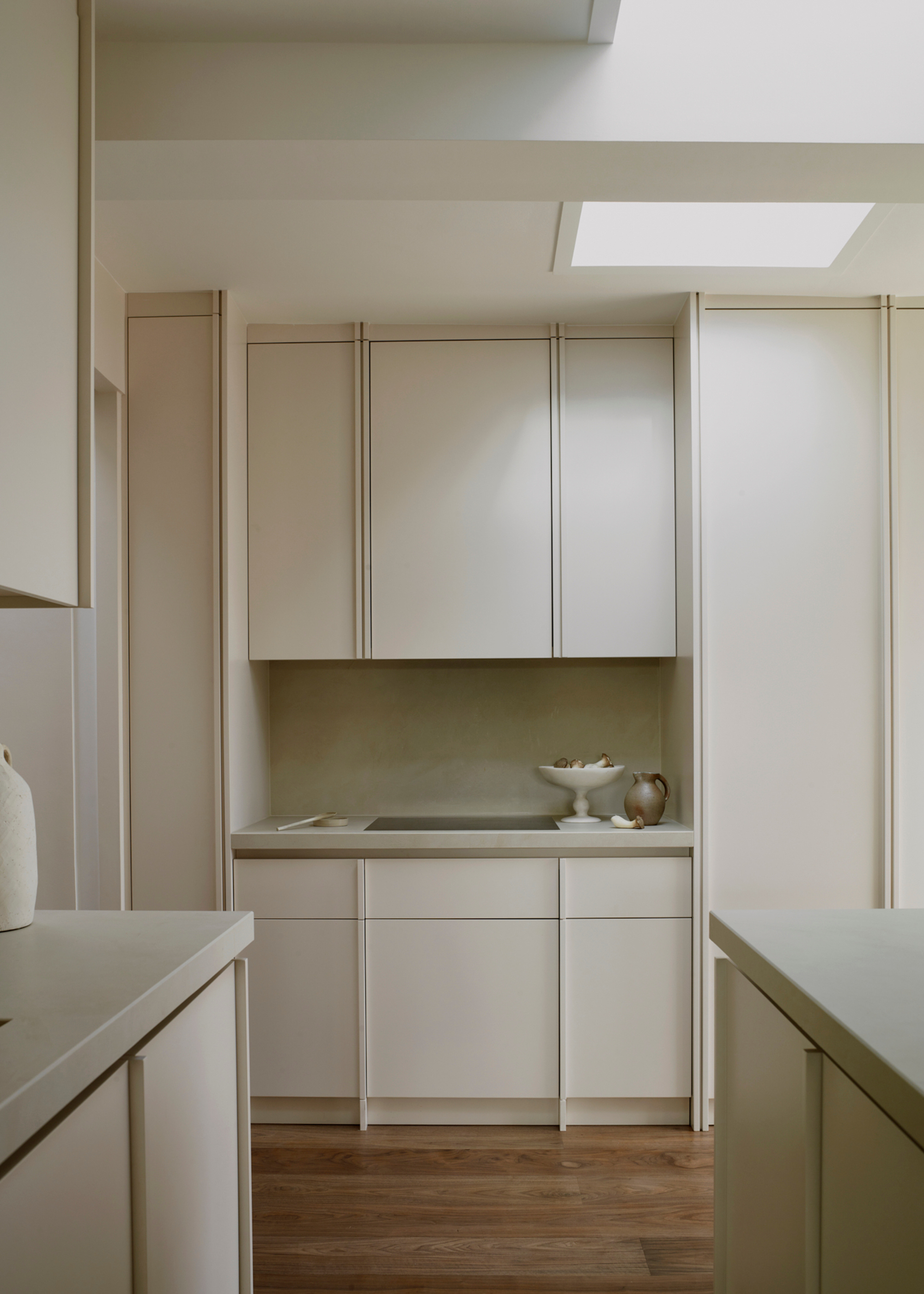 small narrow kitchen with all white finishes and wooden floors