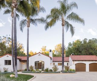 white single story ranch style house with palm trees