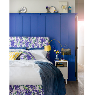 bedroom with blue and white wall and floral designed bed