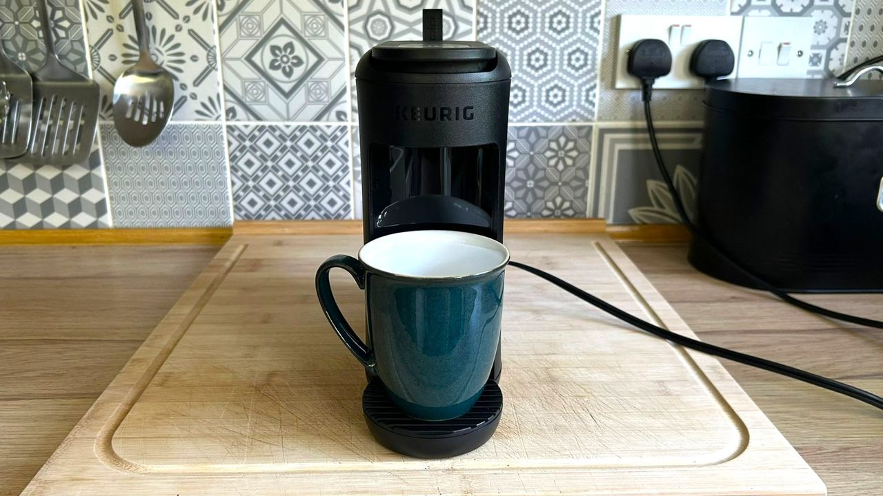 Keurig K-Mini Mate coffee maker on kitchen counter with coffee cup on drip tray