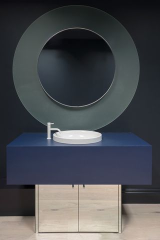 dark bathroom with big round mirror