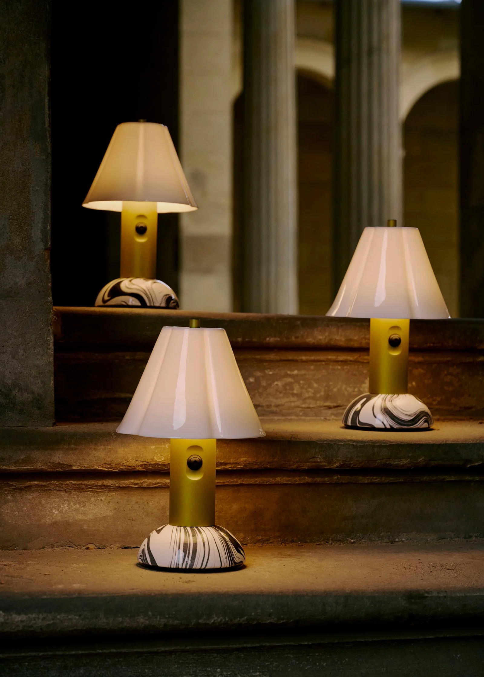 Image of three modern, green and marble, portable table lamps on a brown staircase.