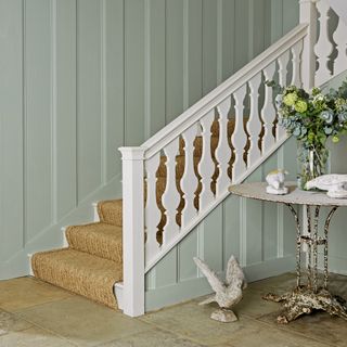 stair case with white railing and flower with glass vase