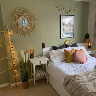 White double bed with two side tables with hanging wall art