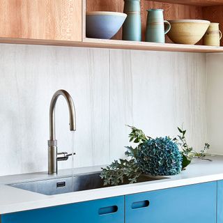 kitchen with blue cabinet and white countertop and washbasin