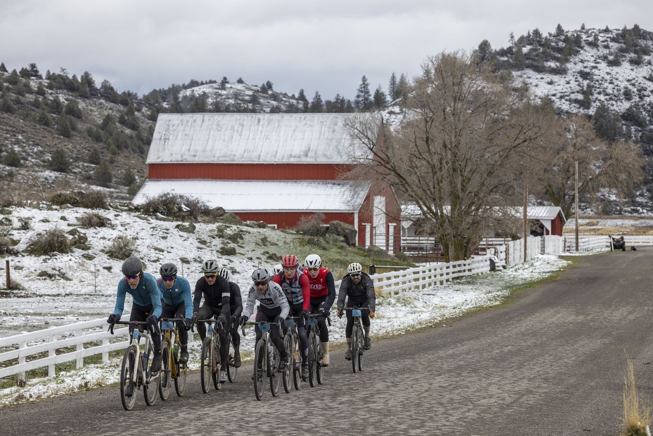 Front group in Open Men's category ride through snow on 2022 Shasta Gravel Hugger in northern California