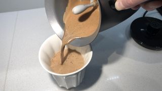 The Hotel Chocolat Velvetiser pouring out hot chocolate into a ceramic cup