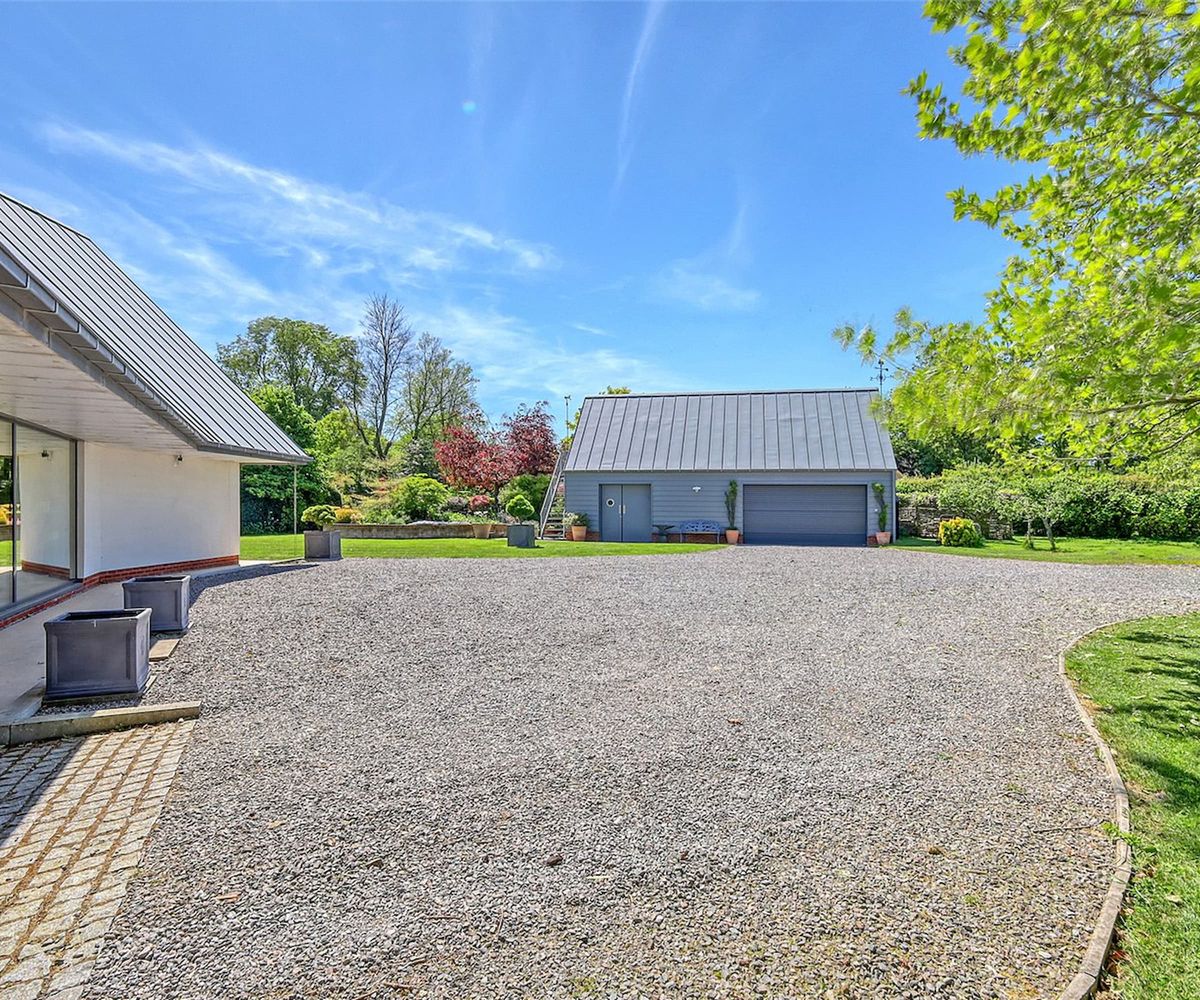 A gravelled driveway and a grey garage