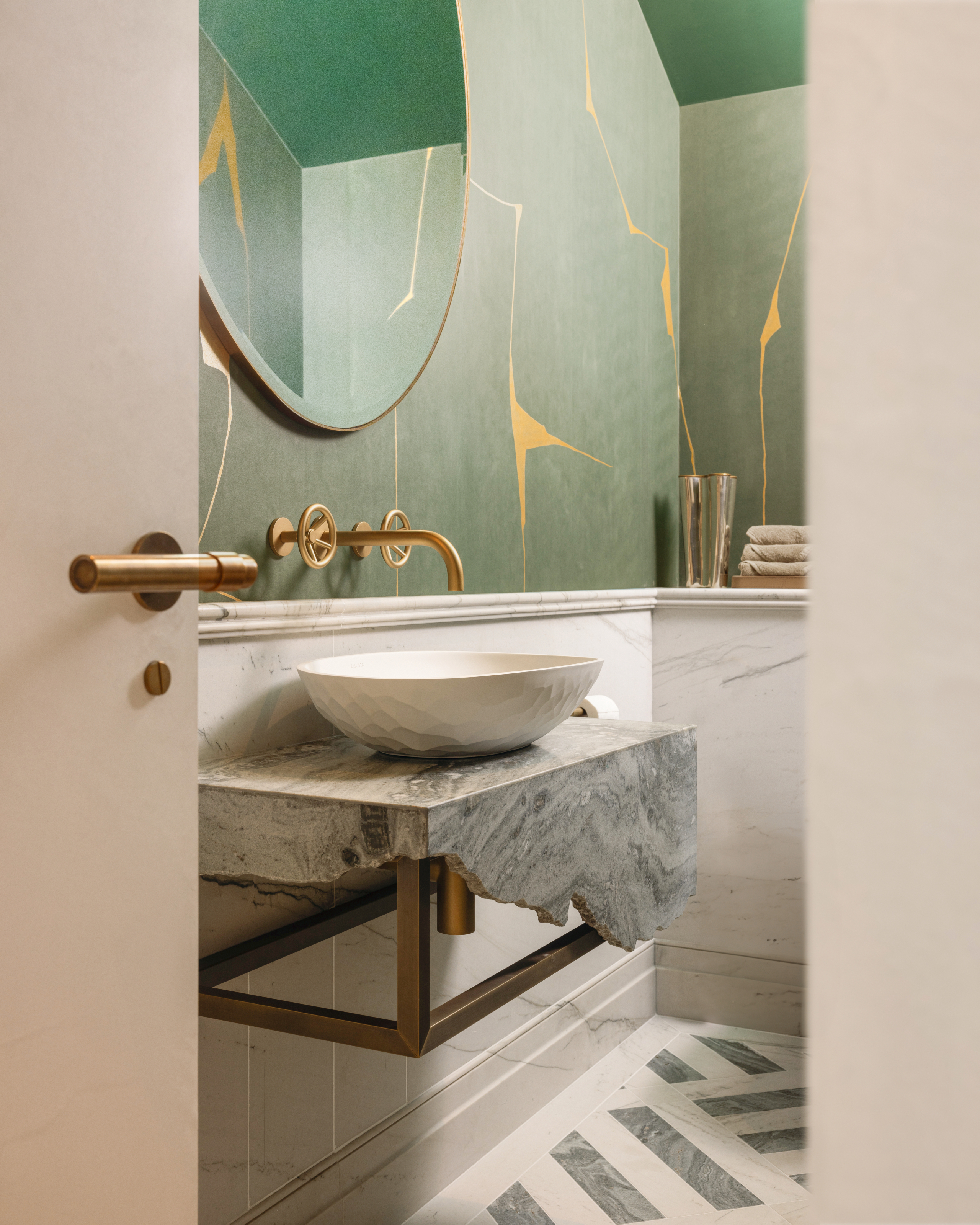 Cloakroom with rough-edged grey marble vanity and green Kintsugi wallpapered walls
