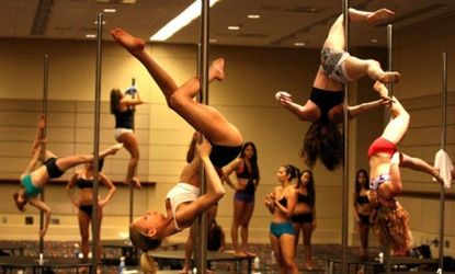 Participants practice a spin move during a pole dancing class in Florida