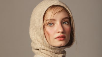 young woman wearing knitted hood - best products for hair loss