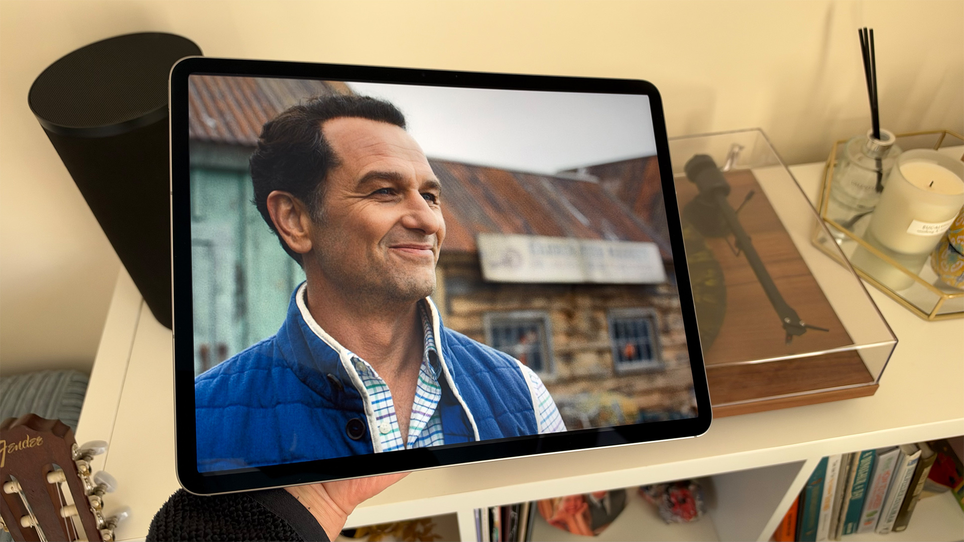 Apple iPad Air 13-inch (M4) tablet held in above turntable, on screen is Apple TV's Widow's Bay