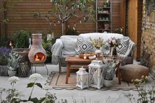 fall backyard ideas with chiminea, blankets and cushions by Wayfair