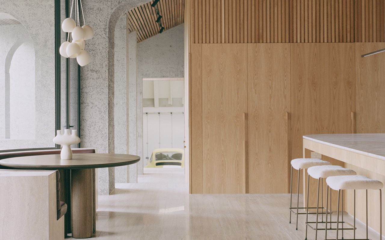 minimalist kitchen with large island and wood slats on the wall