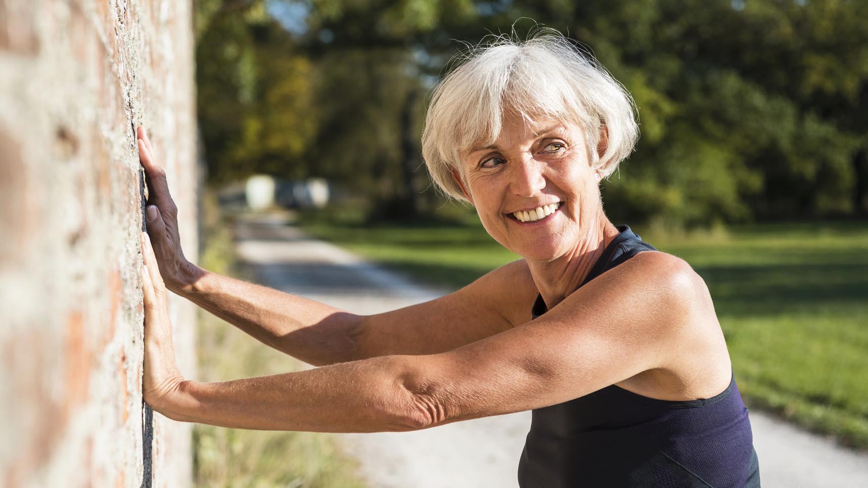 a senior woman exercising against a wall