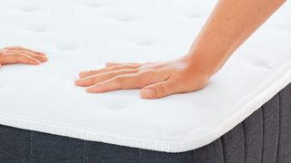 Hands resting on mattress