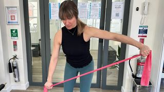 Woman performing a resistance band reverse fly