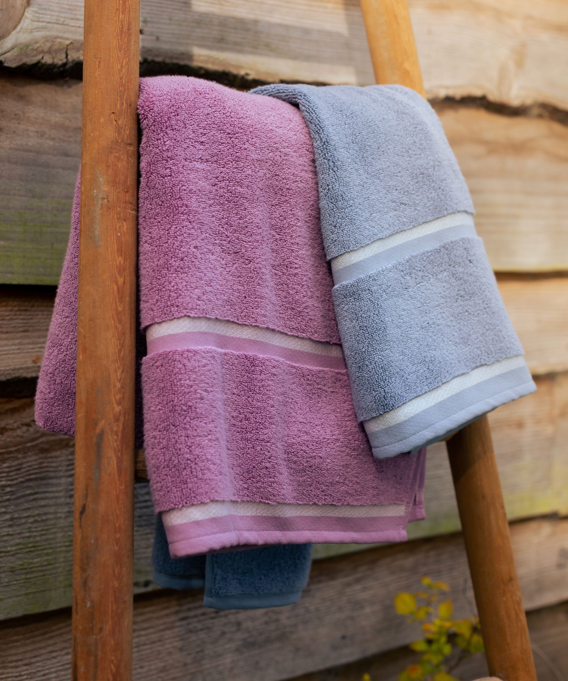 Pink and lavender towel on towel rail leaning against shed