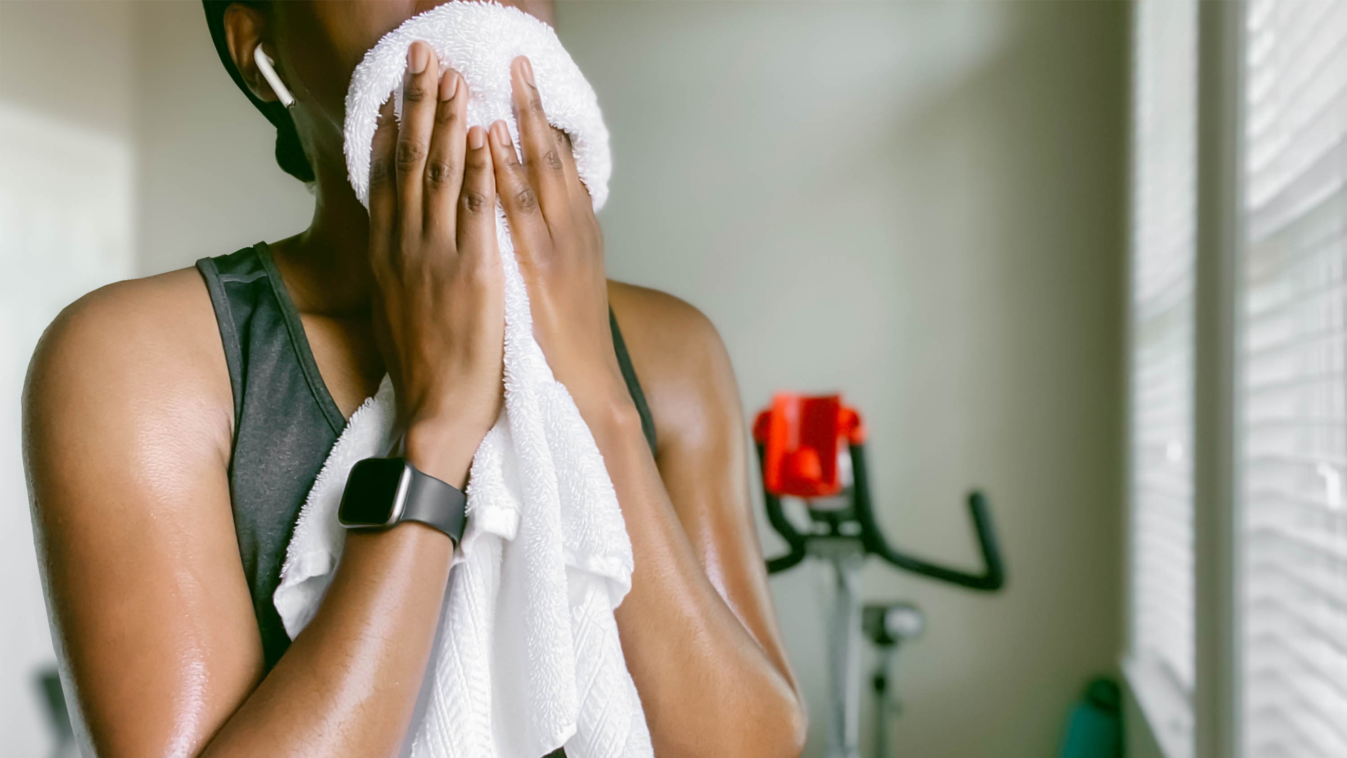 Do exercise bikes burn belly fat? Image of woman using sweat towel after using exercise bike