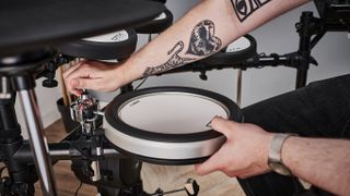 Closeup of a man adjusting the TCS snare pad on a Yamaha DTX6 electronic drum set