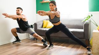 Fit girlfriend and boyfriend working out to reach their fitness goals. Sporty hispanic couple in activewear exercising