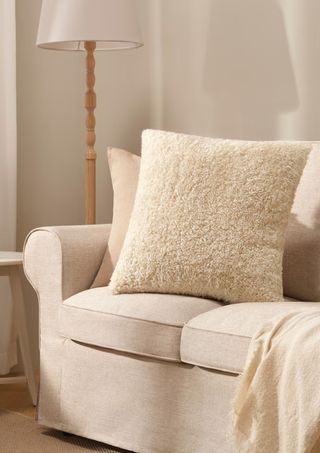 White fluffy throw pillow in a modern, white living room