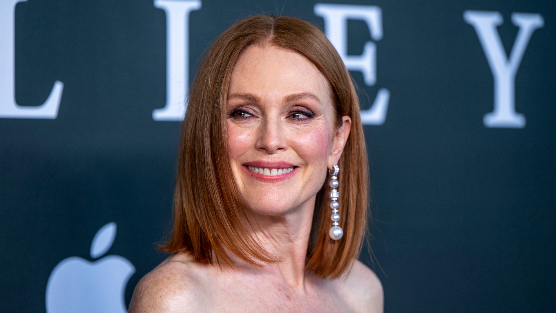 Image of Julianne Moore smiling with straight ginger bob and pearl drop earrings