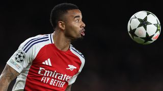 Arsenal's Gabriel Jesus heads the Champions League football in his red and white home shirt.