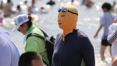 A woman wears facekini on a beach in Qingdao, Shandong Province during a heatwave earlier this month 